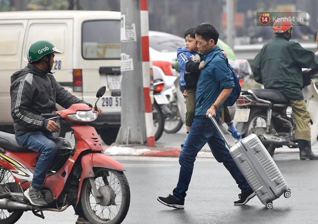Chùm ảnh: Trẻ nhỏ trùm chăn, khoác áo mưa chật vật theo chân bố mẹ rời Thủ đô về quê ăn Tết - Ảnh 13.
