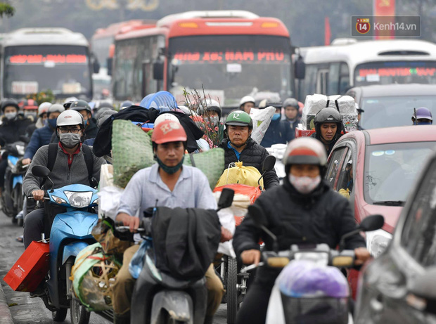 Chùm ảnh: Trẻ nhỏ trùm chăn, khoác áo mưa chật vật theo chân bố mẹ rời Thủ đô về quê ăn Tết - Ảnh 21.
