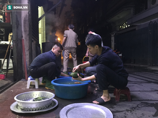 [Ảnh] Độc đáo ở Hà Nội: 10 gia đình luộc chung nồi bánh chưng 100 chiếc trên phố - Ảnh 9.