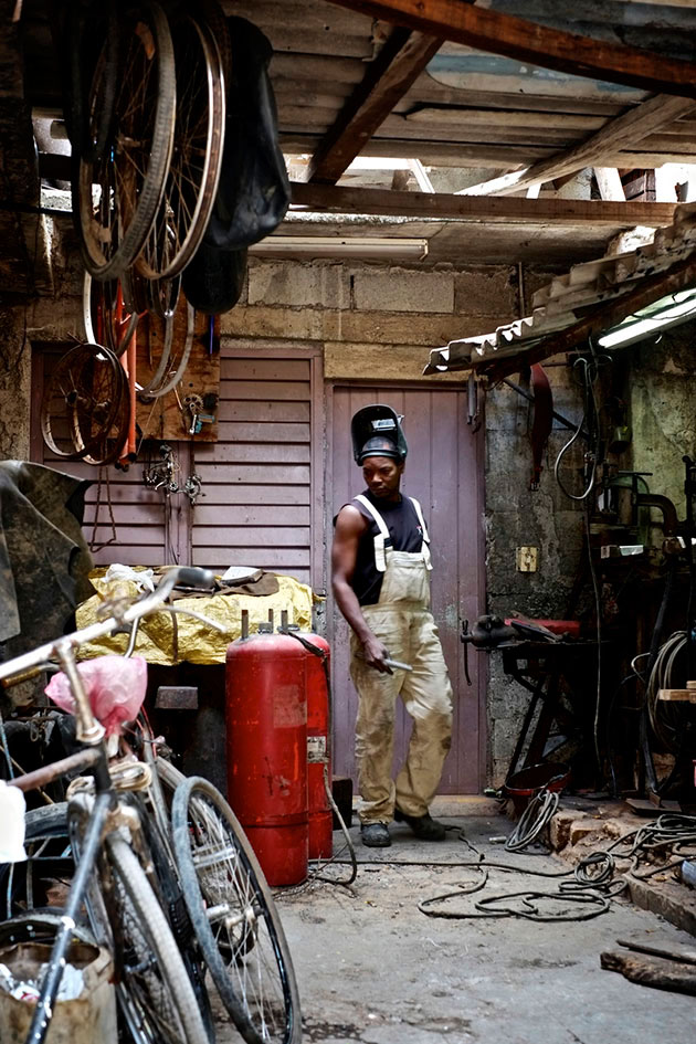 Một thợ sửa xe đạp làm vệc tại cửa hàng của mình ở Old Havana. Hầu hết xe đạp và ô tô cũ tại Havana không bị bỏ đi mà được tái chế lại nhiều lần


