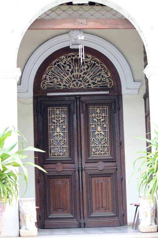 Lối vào có hai lớp cửa, bên trong của gỗ và bên ngoài của cuốn sắt được đẩy lên. Đây là một trong những nét đặc trưng kiến trúc Pháp những năm đầu thế kỉ XX