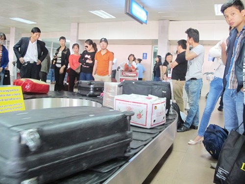 Hành khách chờ lấy hành lý tại sân bay