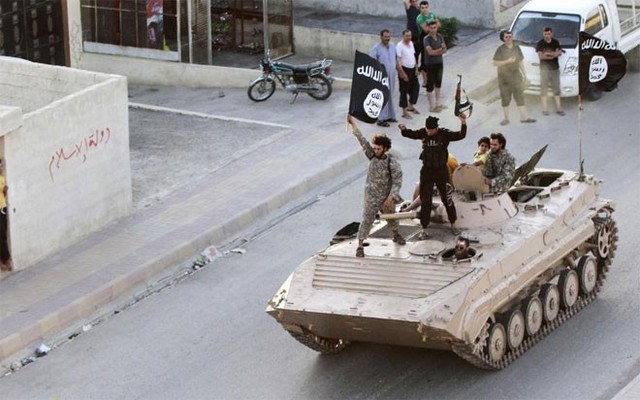 Chiến binh của phiến quân Nhà nước Hồi giáo (IS) diễu hành trên đường phố ở Raqqa, Syria hôm 30/6/2014 - Ảnh: Reuters.