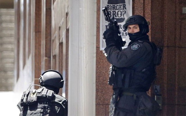 Hai sỹ quan cảnh sát bên ngoài quán Lindt - Ảnh: Reuters/.