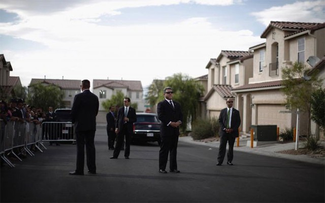 Mật vụ Mỹ đứng gác trên một con phố nơi ông Obama tới thăm một gia đình ở Las Vegas hôm 24/10/2011.