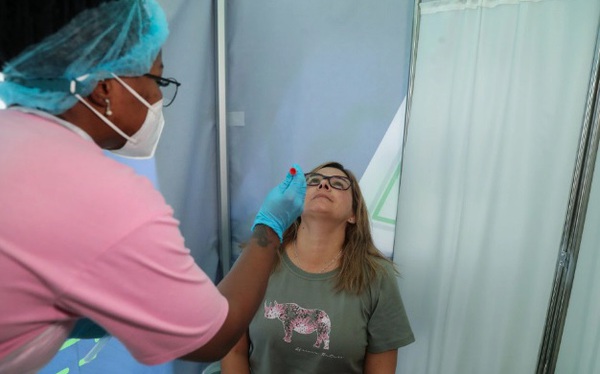 Một nhân viên y tế lấy mẫu xét nghiệm COVID-19 tại Sân bay quốc tế O.R. Tambo ở Johannesburg, Nam Phi, ngày 26 tháng 11 năm 2021. REUTERS / Sumaya Hisham Một nhân viên y tế lấy mẫu xét nghiệm COVID-19 tại Sân bay quốc tế O.R. Tambo ở Johannesburg, Nam Phi, ngày 26 tháng 11 năm 2021. REUTERS / Sumaya Hisham