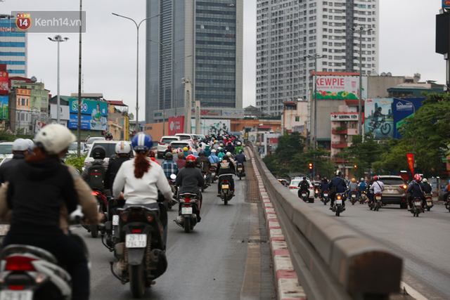 Ảnh: Ngày đầu tiên sau khi nới lỏng cách ly xã hội, đường phố Hà Nội đông đúc kéo dài, người dân chật vật đi làm dưới mưa - Ảnh 4.