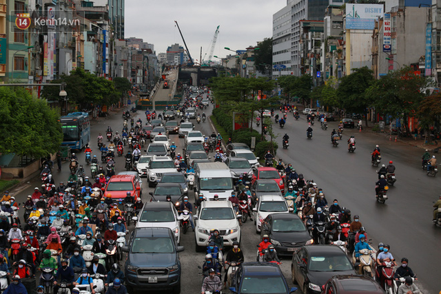 Ảnh: Ngày đầu tiên sau khi nới lỏng cách ly xã hội, đường phố Hà Nội đông đúc kéo dài, người dân chật vật đi làm dưới mưa - Ảnh 6.