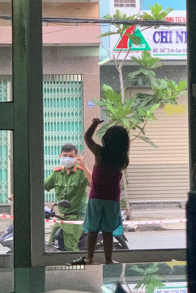 Hình ảnh chiến sĩ công an vùng tâm dịch Đà Nẵng đi qua nhà, vẫy chào con gái qua khung cửa kính gây xúc động - Ảnh 1.
