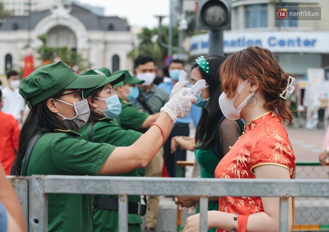 Ảnh: Người Sài Gòn xếp hàng đo thân nhiệt, đeo khẩu trang vào check in đường hoa Nguyễn Huệ - Ảnh 2.