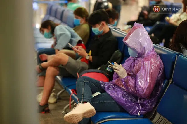 Tối 27 tháng Chạp ở Tân Sơn Nhất: Hành khách mặc áo mưa, đồ bảo hộ kín mít chờ về quê đón Tết - Ảnh 17.