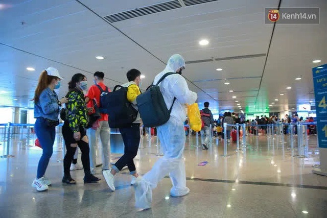 Tối 27 tháng Chạp ở Tân Sơn Nhất: Hành khách mặc áo mưa, đồ bảo hộ kín mít chờ về quê đón Tết - Ảnh 10.