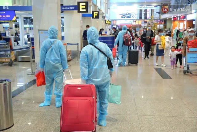 Tối 27 tháng Chạp ở Tân Sơn Nhất: Hành khách mặc áo mưa, đồ bảo hộ kín mít chờ về quê đón Tết - Ảnh 12.