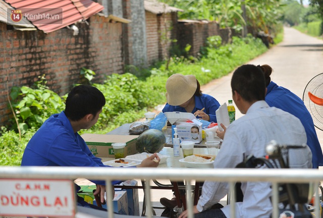 Toàn cảnh phong toả một xã có 7 ca mắc Covid-19 ở Hà Nội: Người dân tiếp tế lương thực giữa trưa nắng - Ảnh 12.