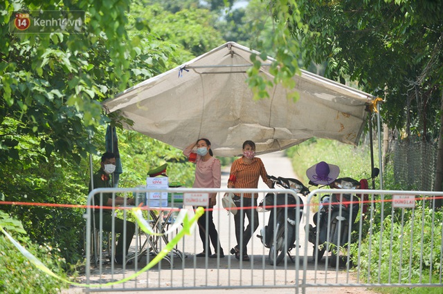 Toàn cảnh phong toả một xã có 7 ca mắc Covid-19 ở Hà Nội: Người dân tiếp tế lương thực giữa trưa nắng - Ảnh 4.