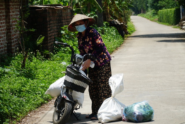 Toàn cảnh phong toả một xã có 7 ca mắc Covid-19 ở Hà Nội: Người dân tiếp tế lương thực giữa trưa nắng - Ảnh 10.