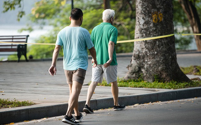 Người dân đi bộ thể dục dù chưa được phép ở Hồ Hoàn Kiếm vào sáng 22/9. Ảnh: Hoàn Như.