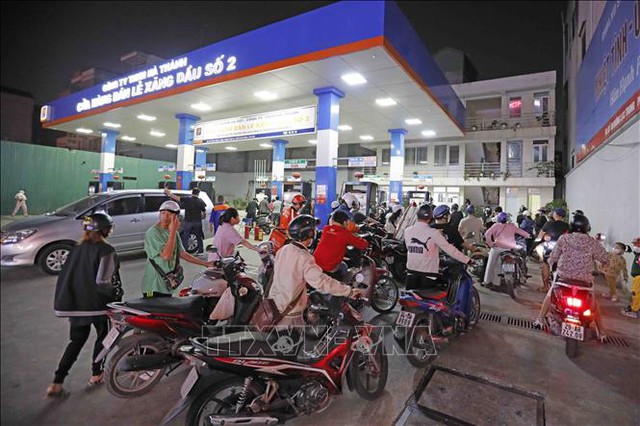 Người dân xếp hàng chờ mua xăng, dầu tại cửa hàng kinh doanh xăng, dầu trên phố Lạc Trung, tối 5/11. Ảnh: Trần Việt/TTXVN