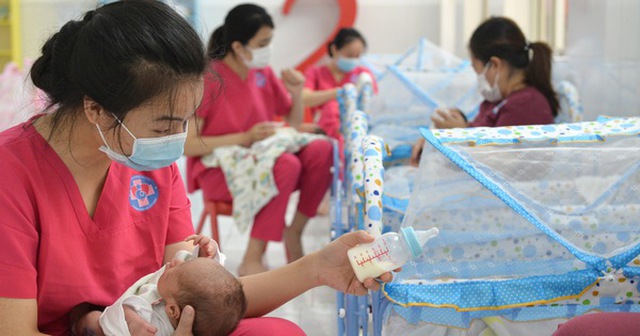 Các tình nguyện viên chăm sóc bé sơ sinh tại Bệnh viện Hùng Vương thời điểm tháng 8-2021 - Ảnh: TỰ TRUNG