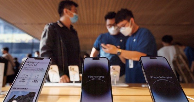 Khách hàng trò chuyện với nhân viên bán hàng trong cửa hàng Apple ở Bắc Kinh - Trung Quốc. Ảnh: Reuters