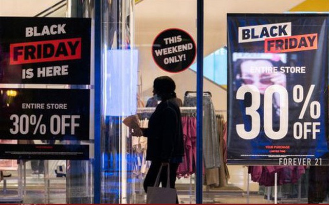Một người phụ nữ đi ngang qua các biển quảng cáo giảm giá Black Friday ở Manhattan, New York (Mỹ). (Ảnh: Reuters)