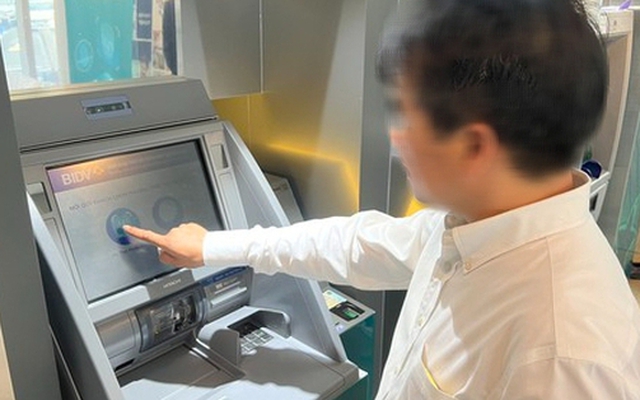 Người dân thực hiện xác thực dấu vân tay khi rút tiền bằng thẻ CCCD gắn chip tại cây ATM trên địa bàn quận Hoàn Kiếm (Hà Nội) - Ảnh: Nguyễn Hưởng