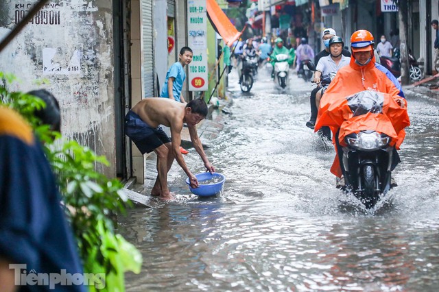 Phố phường Hà Nội ngập trong biển nước chỉ sau 20 phút mưa rào - Ảnh 7.