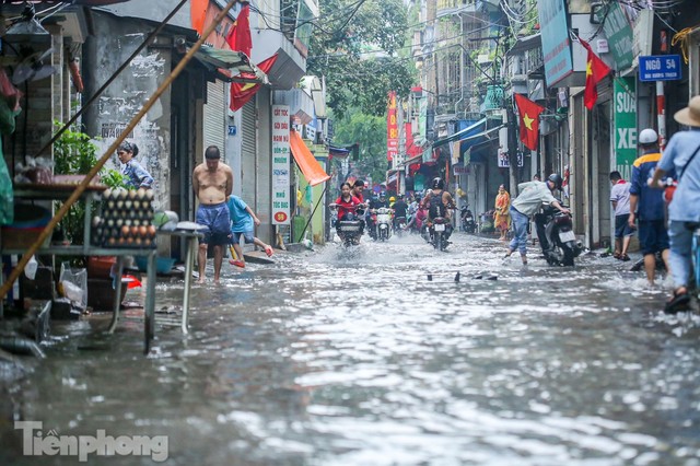 Phố phường Hà Nội ngập trong biển nước chỉ sau 20 phút mưa rào - Ảnh 10.