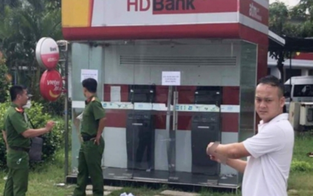 Đối tượng Phước bị cảnh sát đưa tới cây ATM thực nghiệm hiện trường