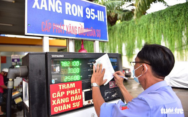 Nhân viên điều chỉnh bảng giá xăng tại một cây xăng ở quận Phú Nhuận, TP.HCM chiều 1-8 - Ảnh: NGỌC PHƯỢNG