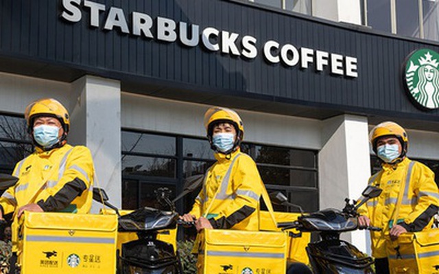 Các nhân viên giao đá lạnh của ứng dụng Meituan đứng trước một cửa hàng Starbucks ở Thượng Hải - Ảnh: SCMP