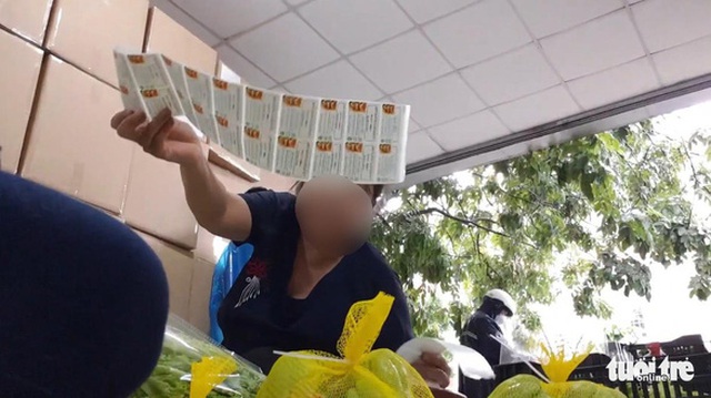 Công nhân dán tem của Nông sản Trình Nhi với nội dung "Rau củ quả Đà Lạt" chuẩn VietGAP lên rau từ chợ đầu mối - Ảnh: BÔNG MAI