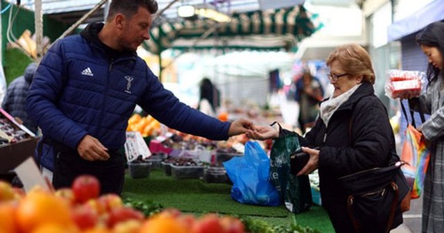 Khách hàng mua thực phẩm tại một quầy hàng trong chợ ở thủ đô London - Anh hôm 27-9 Ảnh: REUTERS