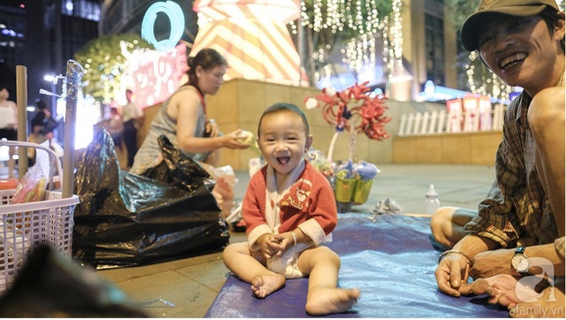 
Noel là mùa lễ chung của Sài Gòn, của ngàn lớp thị dân di cư tứ xứ tới nơi đây mà không phân biệt tạp quán quê xứ. Trong ảnh là bé Kiệt đang chơi đùa với ba mình trong khi mẹ dọn hàng sau một ngày buôn bán vất vả trước Kumho
