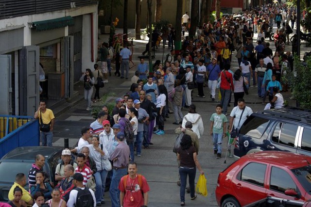 Người dân xếp hàng để ký thác các tờ tiền mệnh giá 100 bolivar của họ tại địa điểm gần Ngân hàng Trung ương Venezuela ở thủ đô Caracas. Theo Reuters, khoảng 40% người dân quốc gia Nam Mỹ này không sở hữu tài khoản ngân hàng và không thể dùng giao dịch điện tử thay thế cho tiền mặt.