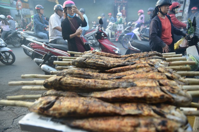 
Người qua đường tranh thủ chụp hình kệ cá trong ngày vía Thần Tài.
