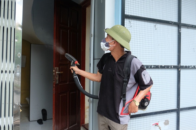 Sáng 22/7, nhiều nhân viên y tế quận Hoàng Mai đi đến từng hộ gia đình phun thuốc diệt muỗi.