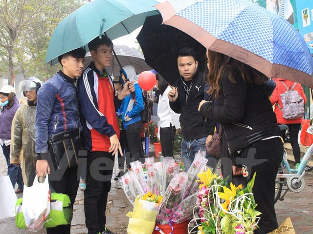 Gian hàng bán hoa của sinh viên thu hút người mua dịp 8/3. (Ảnh: Quế Anh/Vietnam+)