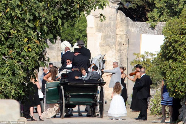 Nhiều khách được đưa vào bằng xe ngựa kéo, bên cạnh là các nhạc công chơi violin.