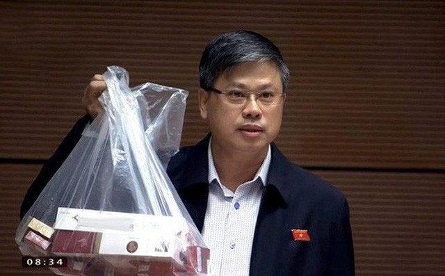 ĐB Nguyễn Sỹ Cương giơ cao túi lớn đựng thuốc lá khi phát biểu trước QH ngày 31-10 - Ảnh: Soha