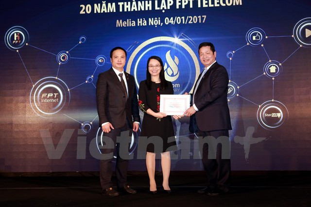 
Bà Chu Thanh Hà thay mặt FPT Telecom nhận bằng khen từ Chủ tịch FPT Trương Gia Bình. (Ảnh: CTV/Vietnam+)
