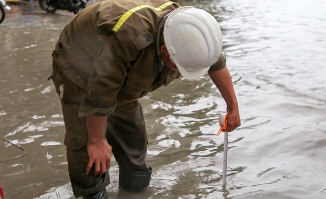 Công nhân đo mực nước để vận hành quái vật hút nước ra sông Sài Gòn.