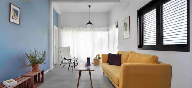 Không gian phòng khách được thiết kế đơn giản với bộ sofa màu vàng nổi bật kê sát tường. Chiếc bàn trà nhỏ với chân cao có thể dễ dang di chuyển để tạo khoảng vui chơi an toàn cho em bé.