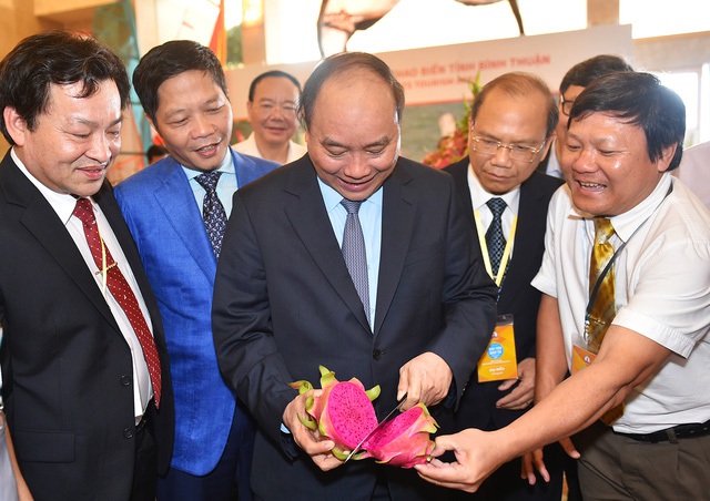 
Thủ tướng với trái thanh long đỏ - biểu tượng trái cây Bình Thuận. Ảnh: VGP/Quang Hiếu

