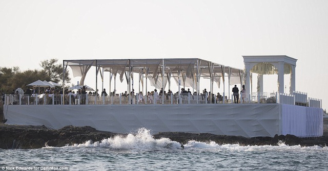 Cặp đôi làm đám cưới dưới một mái vòm với sân khấu tiệc ngay sát bờ biển.