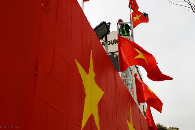 Hà Nội: Bức tường rào 500m2 phủ kín cờ đỏ sao vàng bất ngờ xuất hiện trên đường Nguyễn Trãi khiến người dân thích thú - Ảnh 1.
