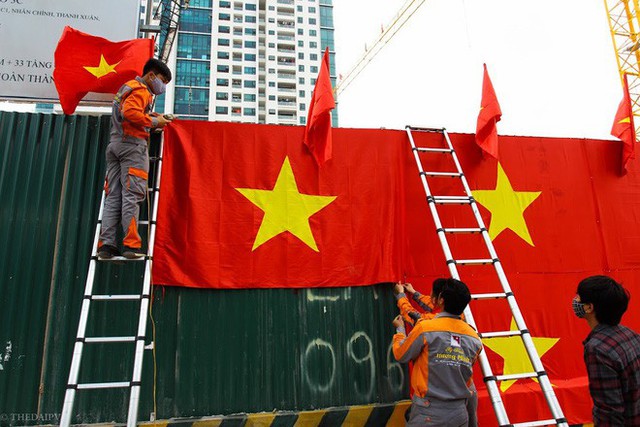 Hà Nội: Bức tường rào 500m2 phủ kín cờ đỏ sao vàng bất ngờ xuất hiện trên đường Nguyễn Trãi khiến người dân thích thú - Ảnh 2.