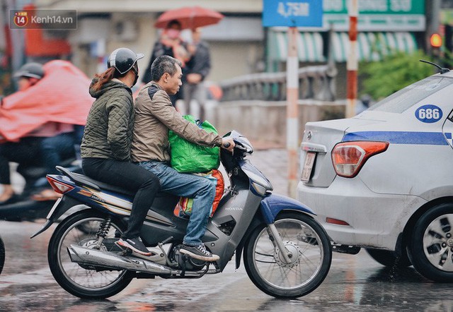 Chùm ảnh: Sau một đêm trở gió Hà Nội mưa lạnh xuống đến 17 độ C, người dân co ro ra đường - Ảnh 10.