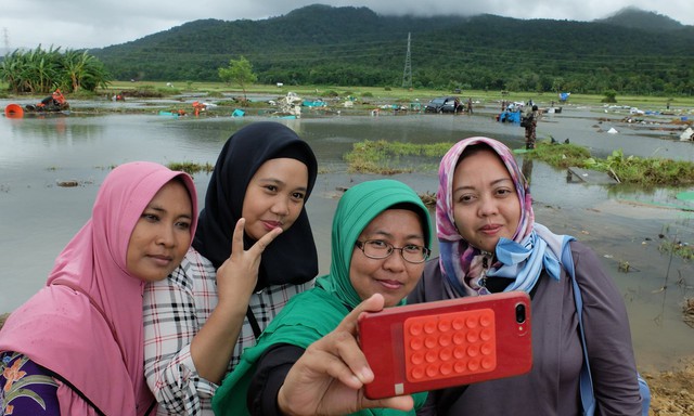 Một số người Indonesia trở về vùng sóng thần tàn phá để chụp ảnh tự sướng: Cảnh hoang tàn mới được nhiều like - Ảnh 1.