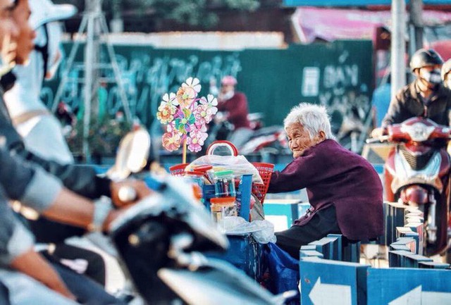 Hình ảnh cụ bà lưng còng gục đầu bên gánh hàng rong giữa ngã tư Hà Nội khiến nhiều người xót xa - Ảnh 2.